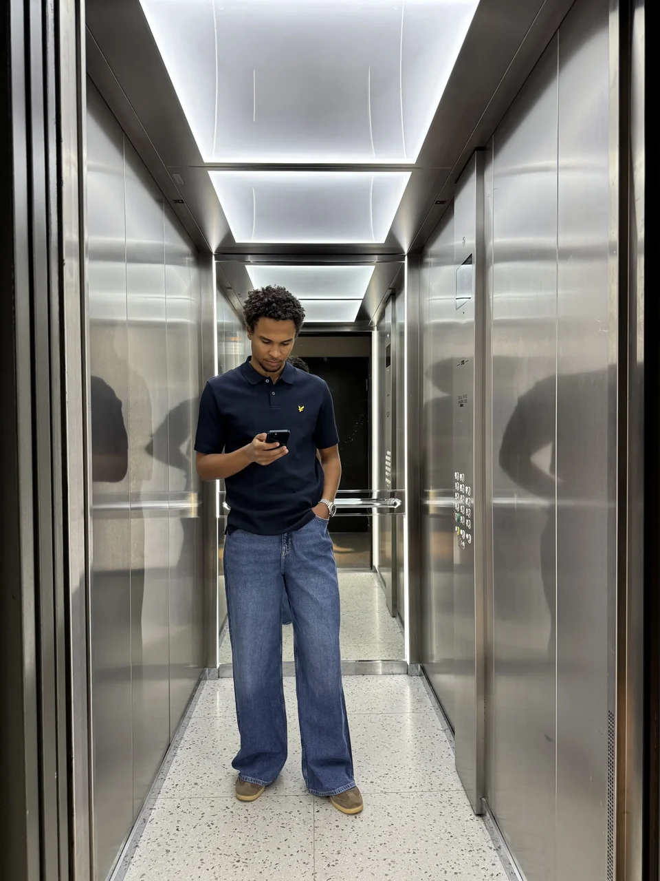 Creator wearing a navy shirt and blue jeans in a lift