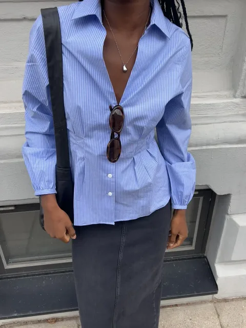 Close-up of a blue striped shirt styled with sunglasses