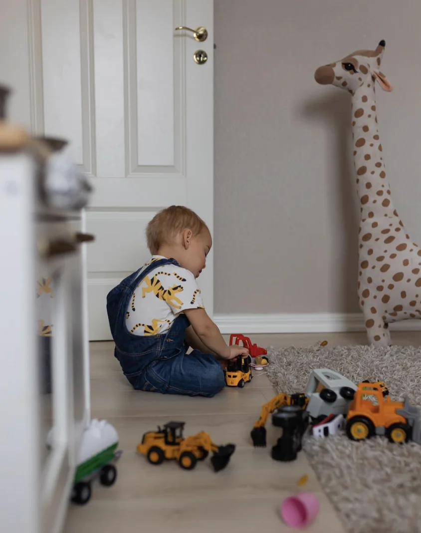 Child playing with toy vehicles