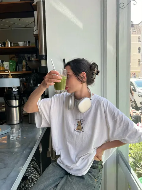 Creator with a green drink at a café