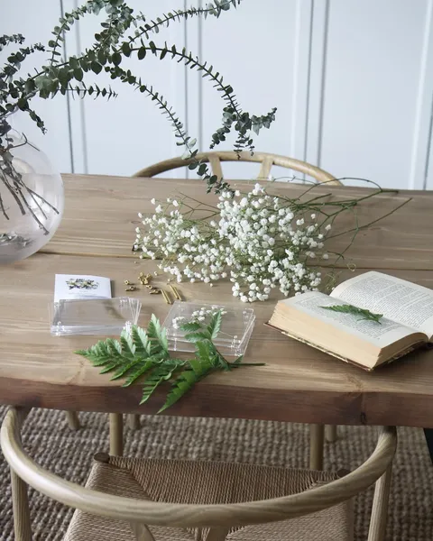 Flowers and a flower press on a wooden table