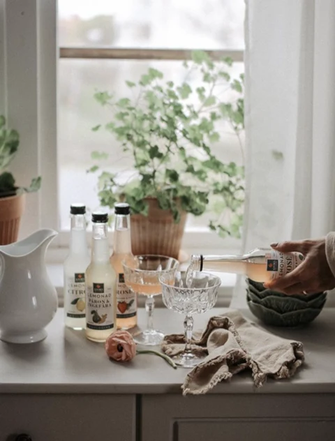 Kiviks drinks on a breakfast table beside a bright window
