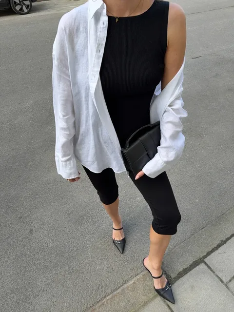 Black outfit styled with an open white shirt