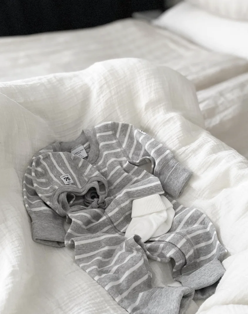 Striped baby clothes on a bed