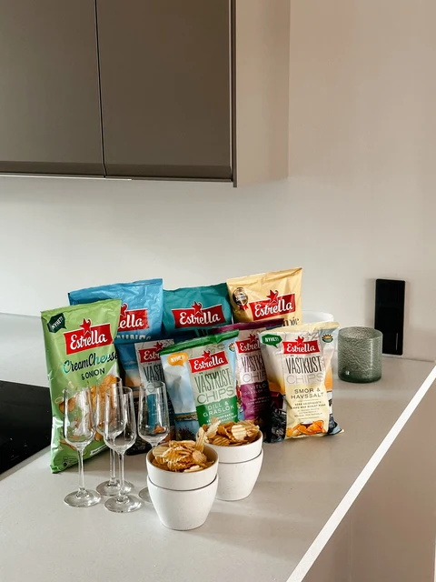 Estrella crisp bags and bowls of crisps arranged on a kitchen counter