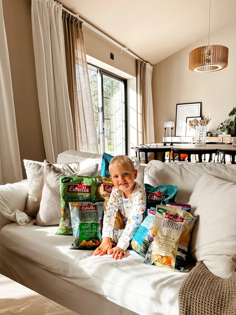 Creator on a sofa with Estrella snack bags