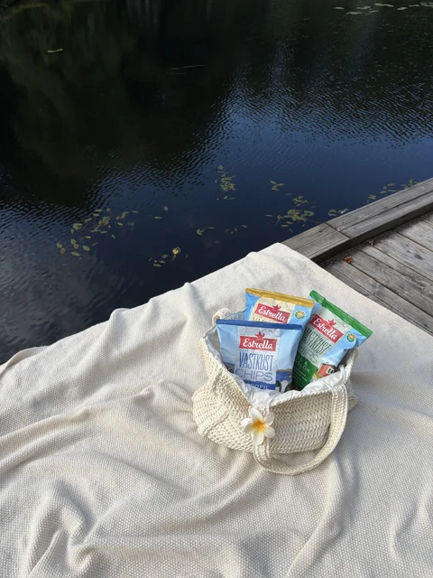 Estrella snack bags on a picnic blanket by the water