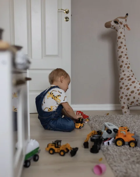 Child playing with toy vehicles