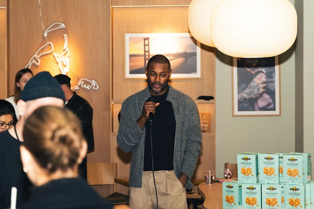 A speaker with a microphone addressing the audience at Joe & The Juice.