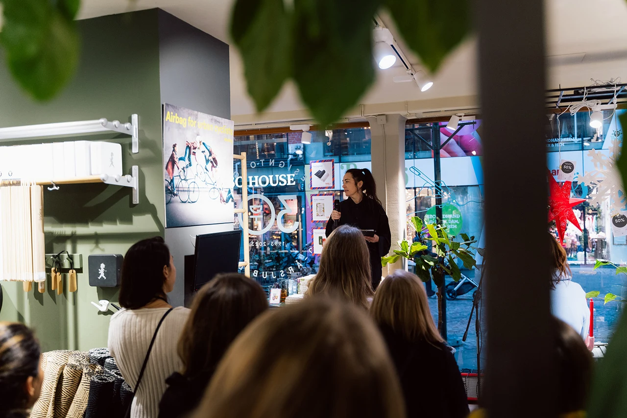 Guests and a speaker in the Christmas-decorated Designtorget store.