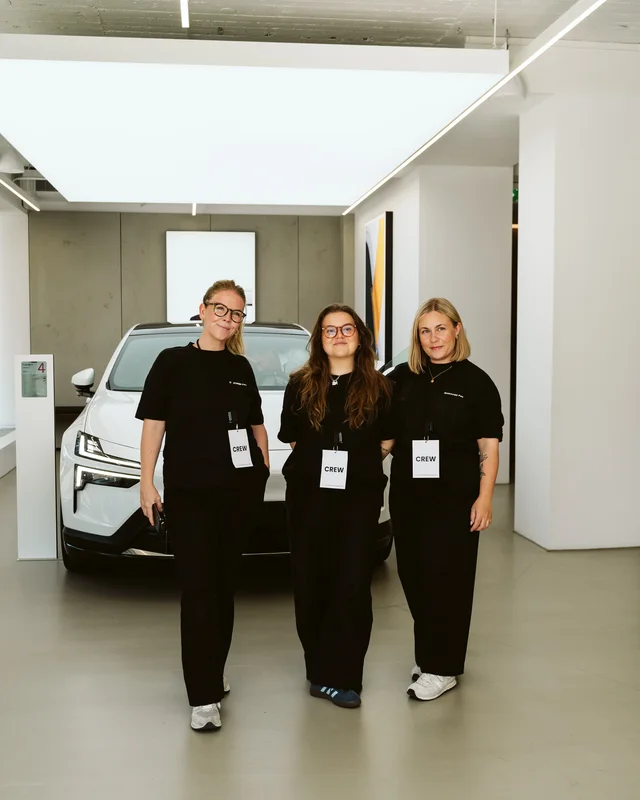 Three event team members in front of a Polestar.