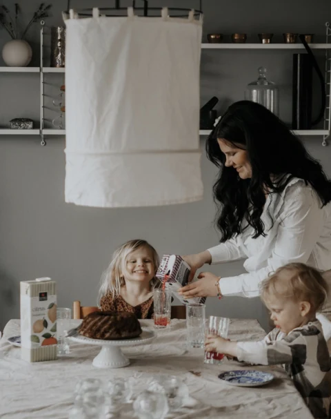 Family preparing breakfast in a kitchen with Kiviks drinks