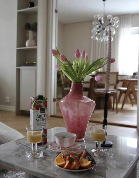 Kiviks apple juice served with breakfast beside a vase of tulips