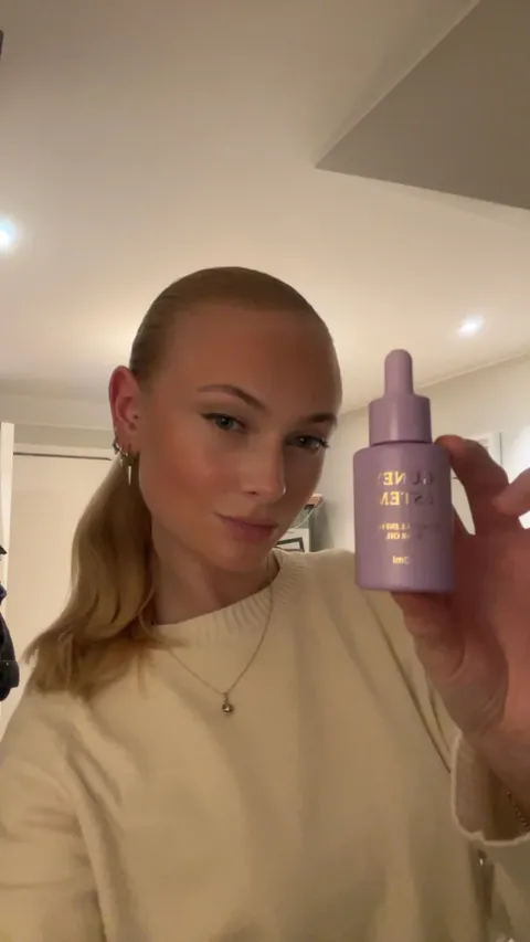 Creator showing Guney & Stem hair oil at home