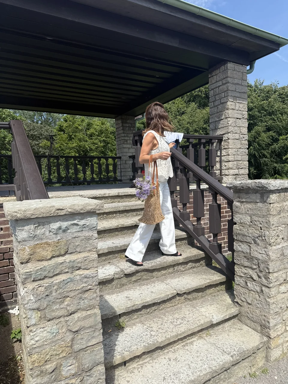 Creator wearing a white outfit on stone steps