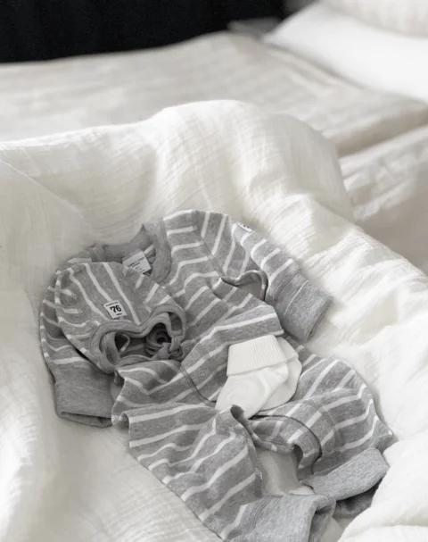 Striped baby clothes on a bed